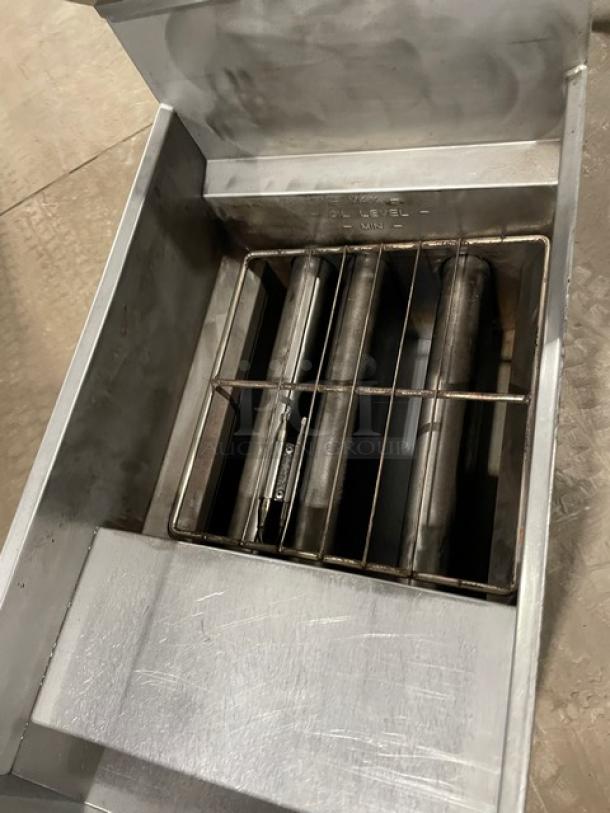 Pitco stainless steel natural gas deep fat fryer, features back splash, basket hanger, and casters, shown in used condition.