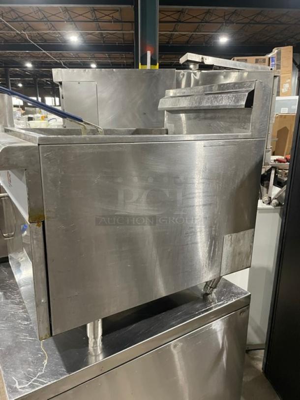 CPG Commercial stainless steel natural gas countertop deep fryer with backsplash, basket hanger, and fry basket on legs.