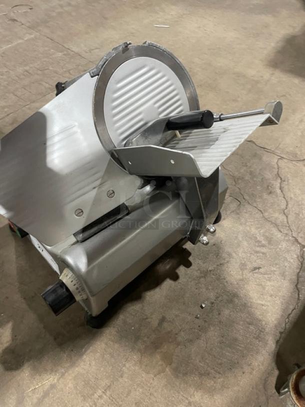 Commercial electric deli meat slicer, model 26MSC001, semi-automatic, 110V, in good condition, on legs.