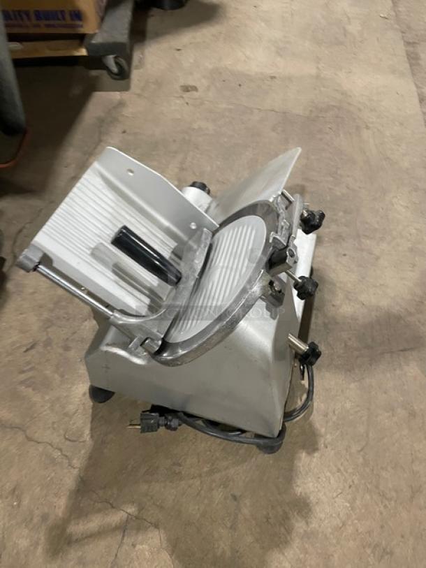 Commercial electric deli meat slicer, model 26MSC001, semi-automatic, 110V, on legs. Appears in used condition.