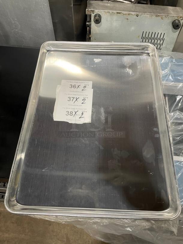 Winco ALXP-1622 aluminum 2/3-size sheet pan, new condition, reflective surface, auction labels partially visible.