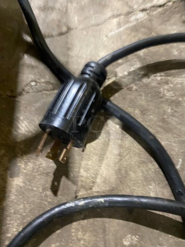 Electric plug for Equipex MAJESTIC sandwich grill. Black cord shown on concrete. 208/240V electric powered.