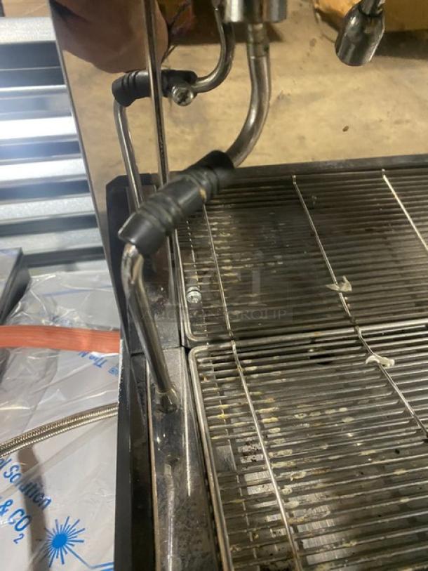 Conti CC103DTC espresso machine, stainless steel, with steam wand and drip tray. Features 3-group setup, on legs.