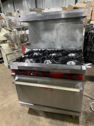 Vulcan stainless steel 6-burner range/oven combo with backsplash, overhead salamander shelf, and wired oven rack. Natural gas powered.