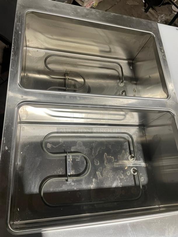 Prepline EST302O commercial electric 2-well steam table with cutting board, stainless steel, single undershelf, 120V, on legs.