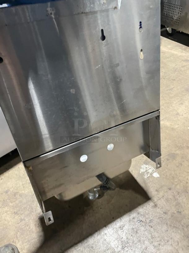 Advance Tabco stainless steel wall-mount hand sink with backsplash, built-in paper towel dispenser, and visible mounting holes.