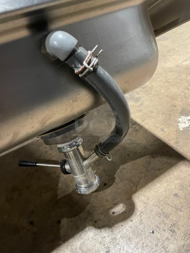 Advance Tabco stainless steel wall-mount hand sink, featuring a single well, backsplash, and paper towel dispenser attachment.