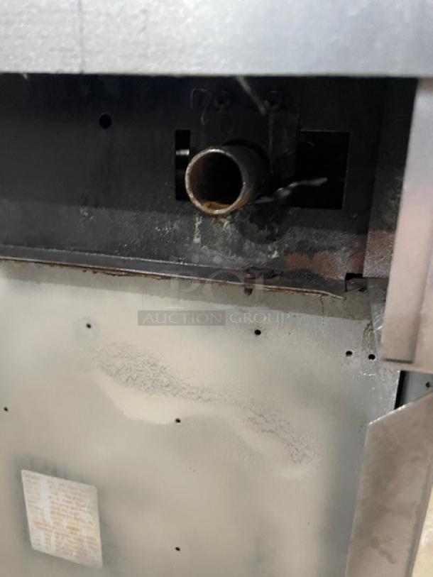 Garland stainless steel natural gas 6-burner range/oven combo detail, featuring overhead salamander shelf, backsplash, on casters.