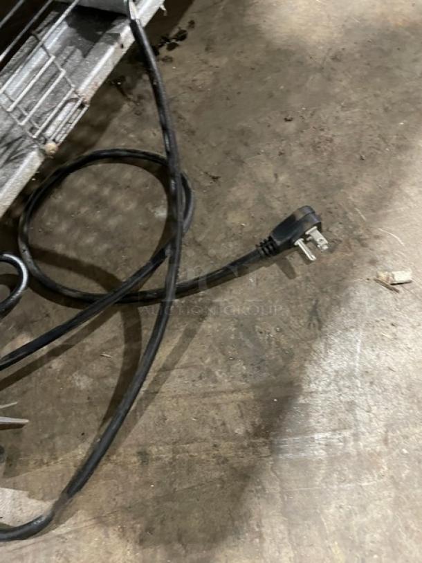 Turbo Air MST-60-24-N commercial refrigerated prep table power cord on floor, with poly-coated wired rack visible.