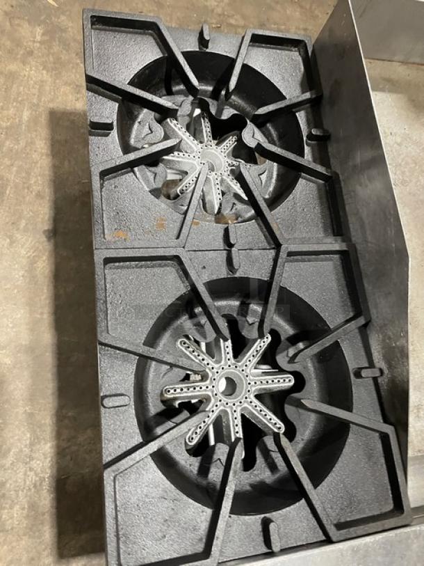 Comstock-Castle FHP3624 stainless steel 2-burner countertop range with griddle, back, and side splash, on legs.