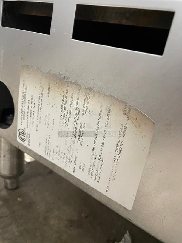 Comstock-Castle FHP3624 commercial stainless steel griddle range, 2-burner, with back and side splash, natural gas powered, on legs, model info visible on label.