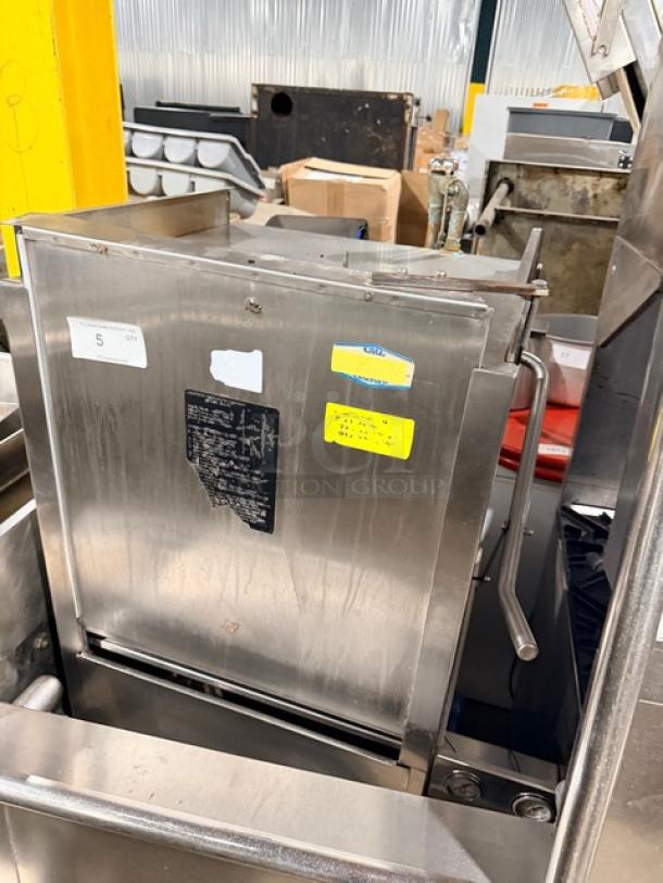 Jackson commercial stainless steel door-type dishwasher; electric powered, heavy duty. Features L-shaped washing station, on legs. Visible condition: used, with manufacturer labels and operation instructions.