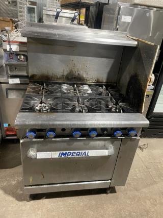 Imperial stainless steel 6-burner gas range/oven combo with back and side splash, overhead salamander shelf, wired oven rack, on casters.