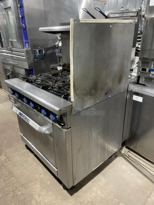 Imperial stainless steel 6-burner range/oven with splash guards and salamander shelf, on casters. Natural gas powered.