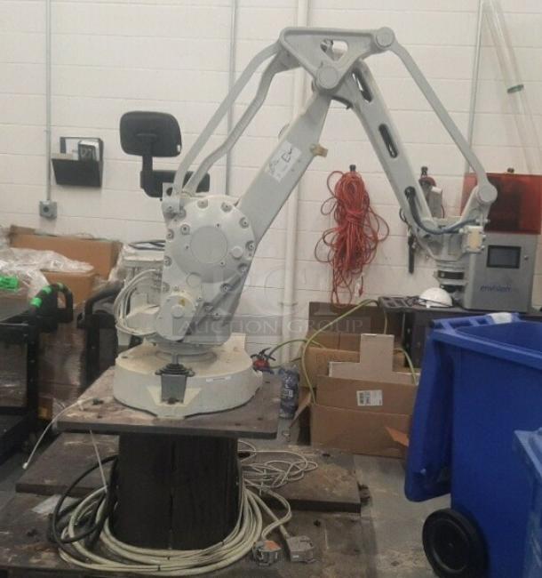 ABB IRB 260 industrial robot arm, 61" reach, 66 lbs capacity, with coding controller pendant, shown in a warehouse setting.