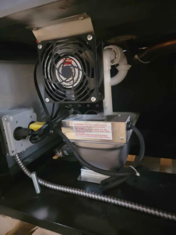 RPI Industries Bandit Air Screen refrigeration unit interior, featuring attached wiring and a caution label indicating electric shock hazard.