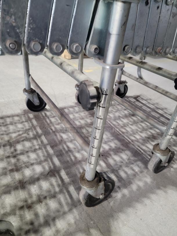 Nestaflex 275 heavy-duty expandable gravity roller conveyor with adjustable legs, locking casters, and steel construction.