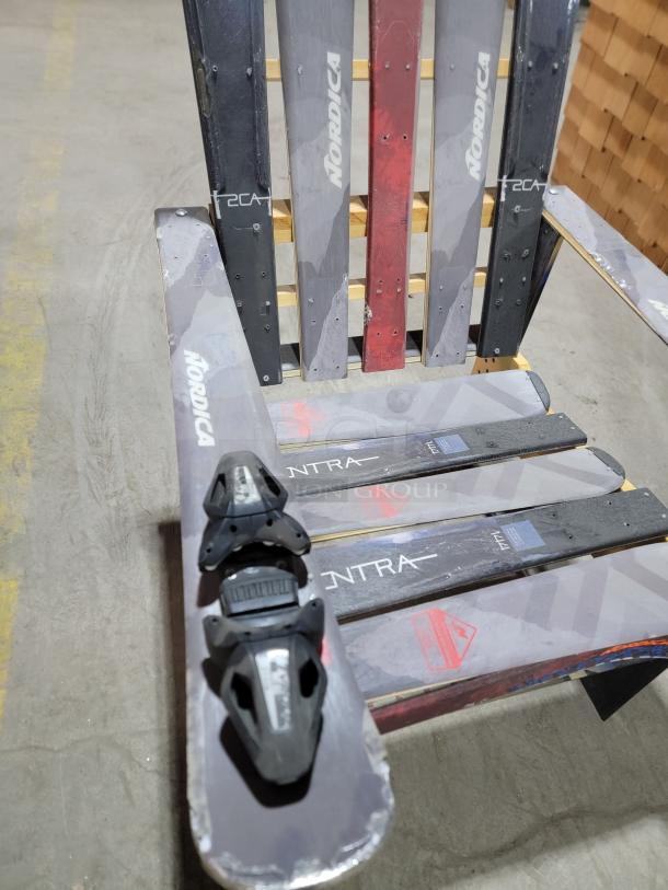 Handcrafted Adirondack-style chair made from upcycled Nordica skis, featuring ski bindings, ideal for outdoor or ski-themed decor.