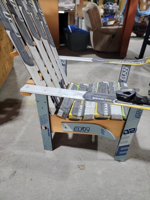 Unique Adirondack chair made from upcycled Elan skis, featuring vibrant colors and brand markings. Ideal for patios.