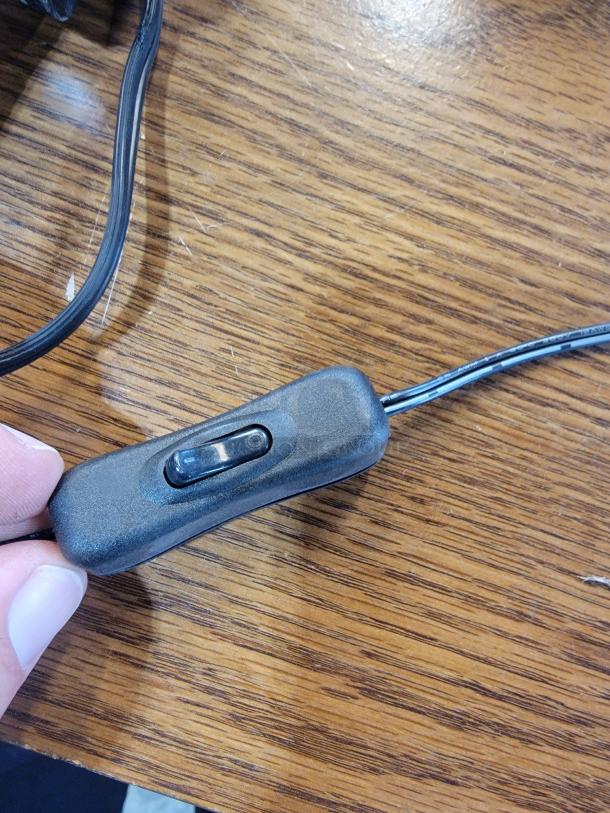 Control switch for Element Lux Neon LED OPEN Sign, Model OpenSign1. Black plastic with a slide button, attached to a cord.