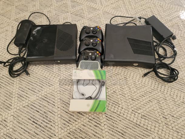 Two Xbox 360 S consoles with controllers, power supplies, headset, and chat pad on a carpet. Complete gaming bundle.