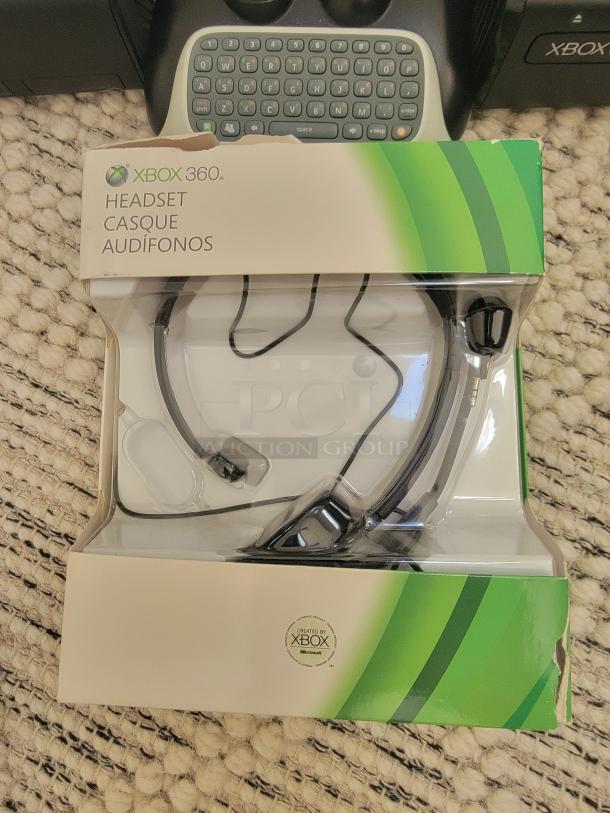Xbox 360 headset in original packaging with visible Xbox branding. Mild wear on the box edges.
