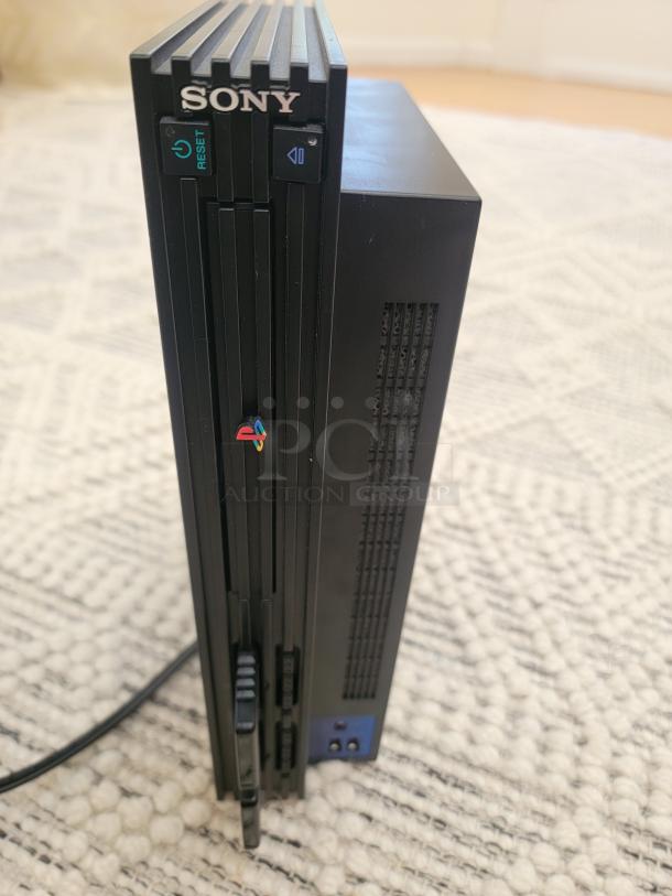 Sony PlayStation 2 fat model console in black, featuring power and reset buttons.
