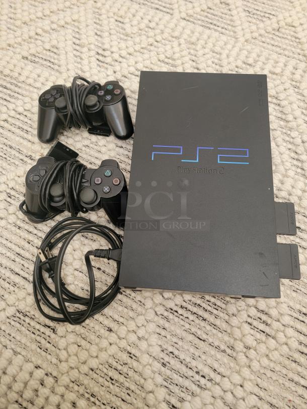 Sony PlayStation 2 Fat Model with two controllers and power cable. Classic console in good condition for retro gaming.