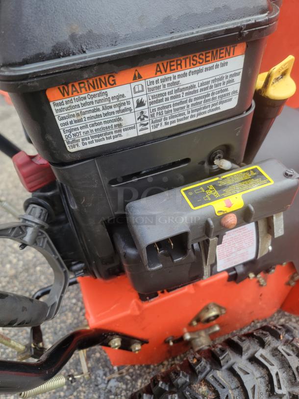 Ariens Deluxe 24" snow blower engine section with visible warning labels. Model 921011 in excellent condition.