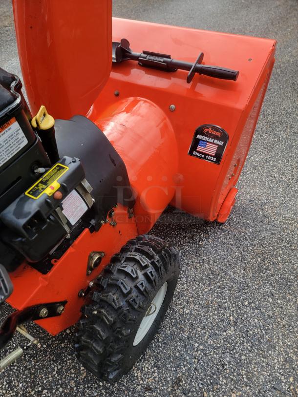 Ariens Deluxe 24" snow blower, model 921011, in excellent condition. Features durable two-stage mechanism and sturdy tires.