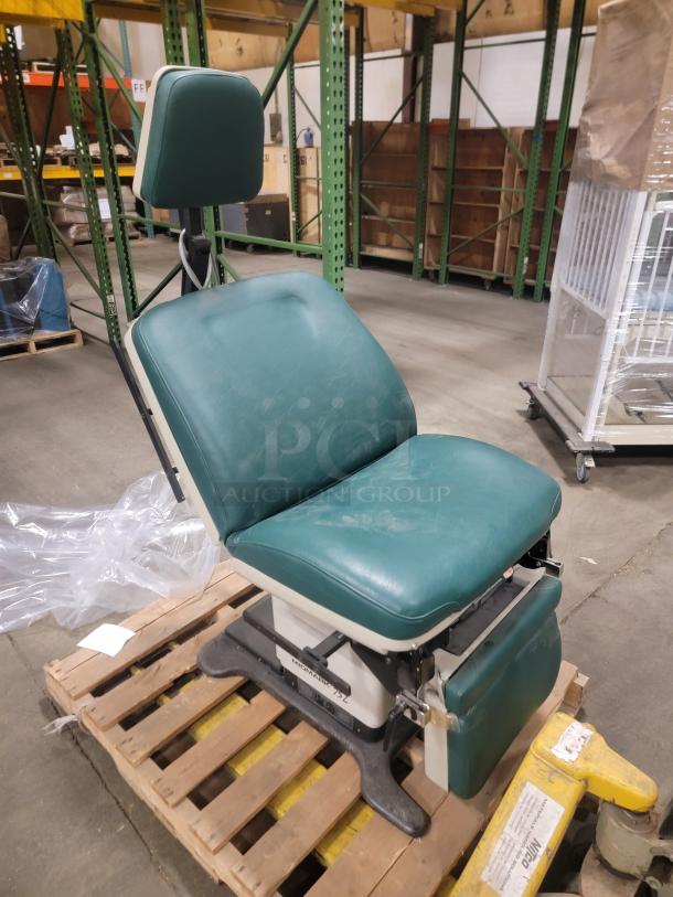 Midmark 75L medical examination chair on pallet, green upholstery, adjustable, durable build, ideal for gaming or office use.