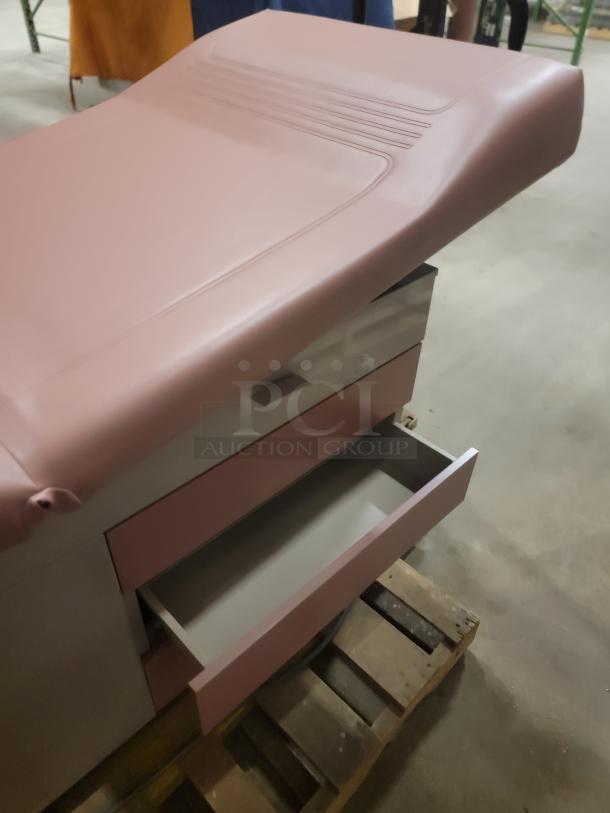 Riter/Brewer 104/Access power examination table, pink upholstery, open storage drawer, sturdy design, versatile use.