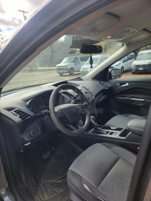 2018 Ford Escape SE interior, showing gray fabric seats, steering wheel with controls, and gear shift. Clean, well-maintained condition.