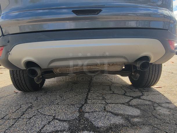 Rear view of a 2018 Ford Escape SE 4WD, showing dual exhausts and tires. Rust visible, indicating wear.