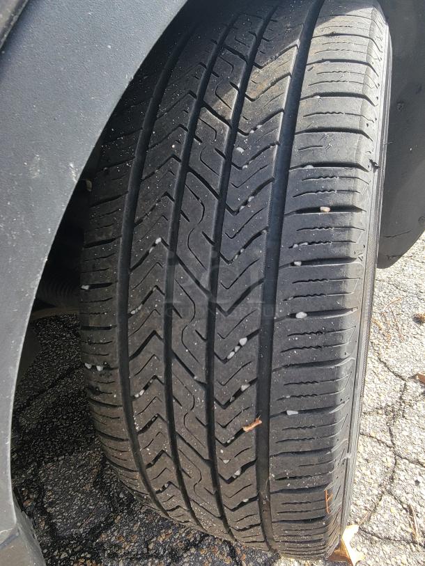 Close-up of a 2018 Ford Escape SE 4WD tire with good tread, indicating winter readiness. Tire surface shows minor road wear.