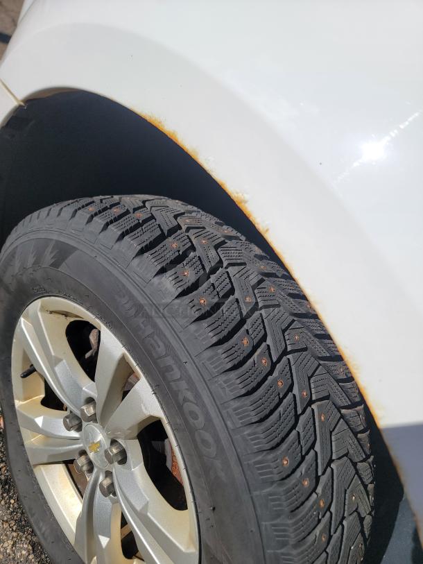 2015 Chevy Equinox wheel and tire detail. Visible rust on wheel arch. Hankook tire in good condition.
