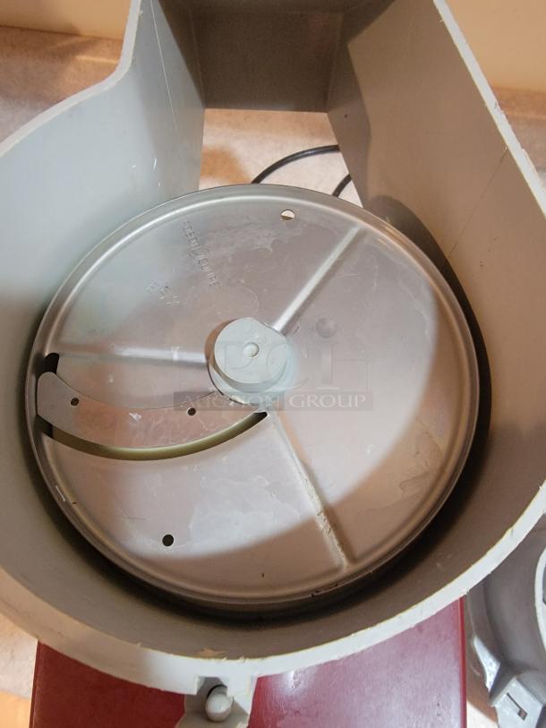 Robot Coupe R2NCLR food processor with slicing disc, showing wear but in working condition, features versatile chopping and blending capabilities.