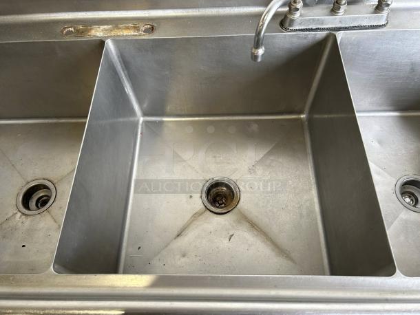 Commercial 3-compartment stainless steel sink with double drainboards, custom-fabricated, in great condition, fully tested.