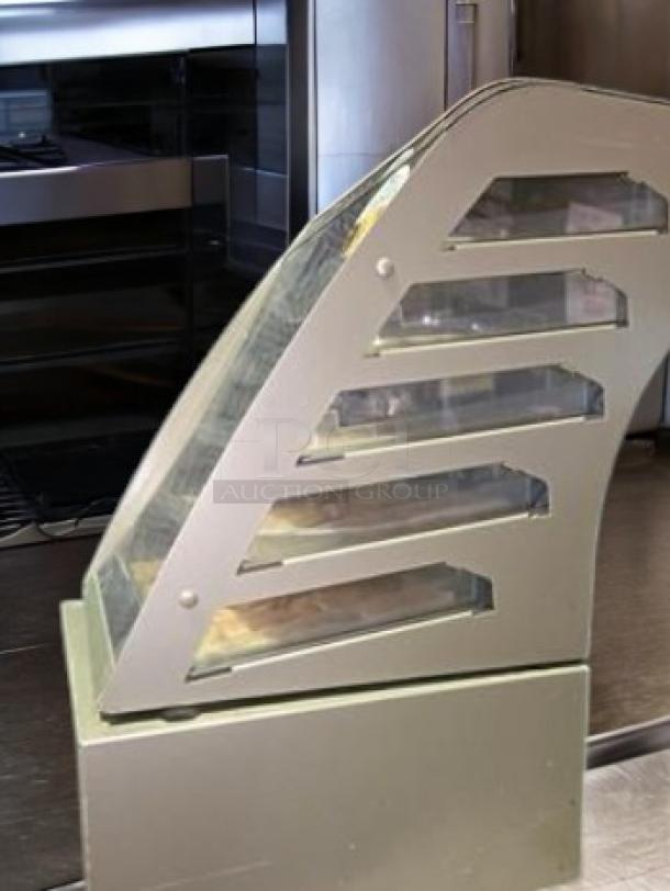 Subway 4-tier cookie display case in superb condition, tested and functional. Features a curved glass front and metallic frame.