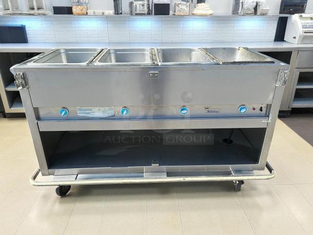 Duke E304 hot food table with 4 wells, cutting board, and controls. Stainless steel, tested, 240V/1PH. Adjustable wheels.