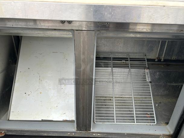 Continental Refrigerator SW72N30M-FB 3-door sandwich prep table, internal view, showing wire shelf and clean interior.