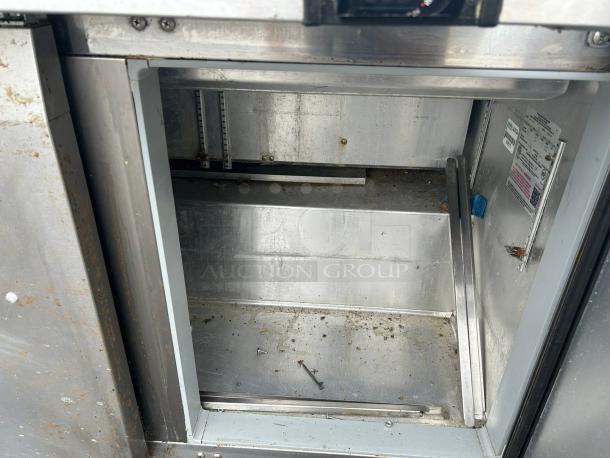 Continental Refrigerator SW72N30M-FB 72" 3 Door sandwich prep table interior view showing stainless steel insides and label.