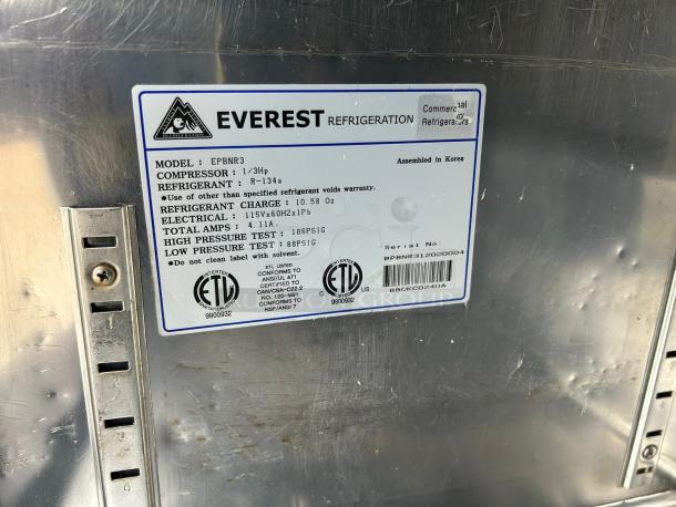 Everest Refrigeration EPBNR3 label on stainless surface; model, compressor, refrigerant, and electrical specs detailed.