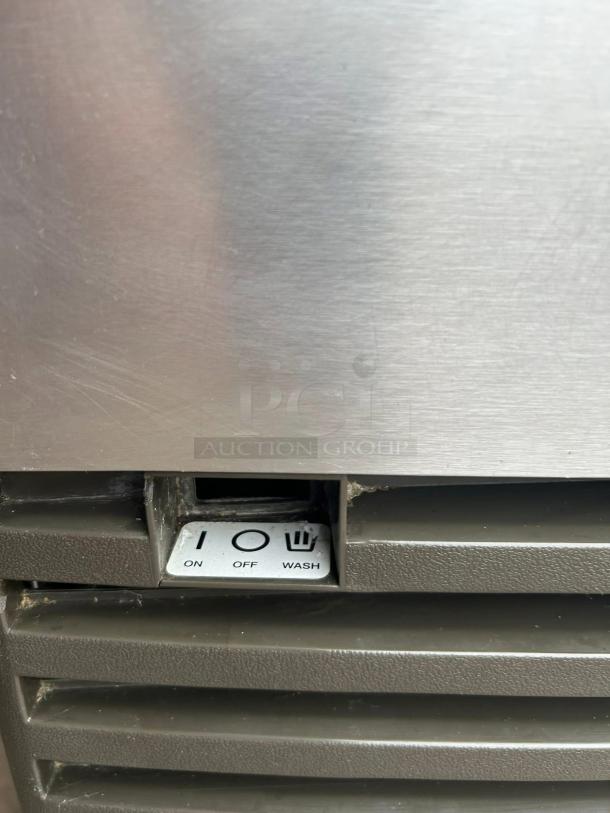 Manitowoc QD-0272A undercounter ice machine control panel with on, off, and wash settings on a stainless steel exterior.