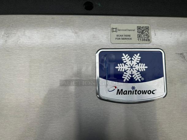 Manitowoc IYT0900A ice machine head close-up with brand logo and service QR code, indicating model and condition.