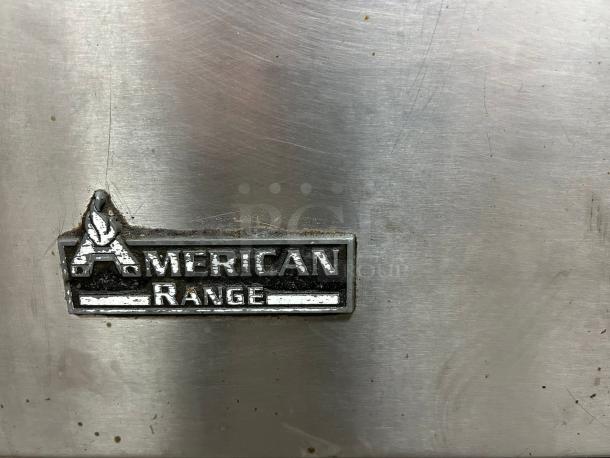 American Range AR-6 logo on stainless steel commercial gas range, showing some wear.