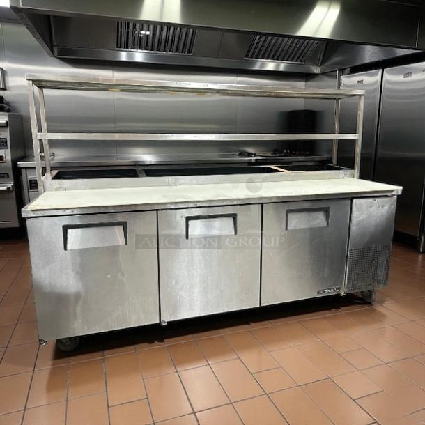 True TPP-AT2-93-HC 93.5” 3-door refrigerated pizza prep table with overshelf, tested and working. Stainless steel finish.