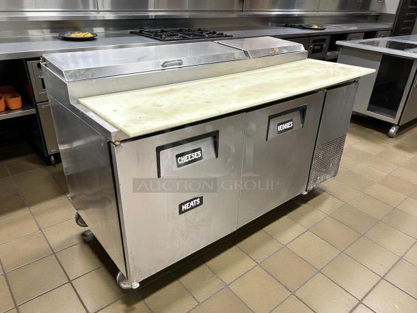True TPP-AT-67-HC refrigerated pizza prep table, 67" width, two doors labeled for cheese and vegetables, stainless steel, tested and working.
