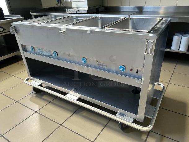 Alt text: Duke E304 Aerohot electric 4-well steamtable in great condition, 208V. Stainless steel with blue knobs, on wheels.