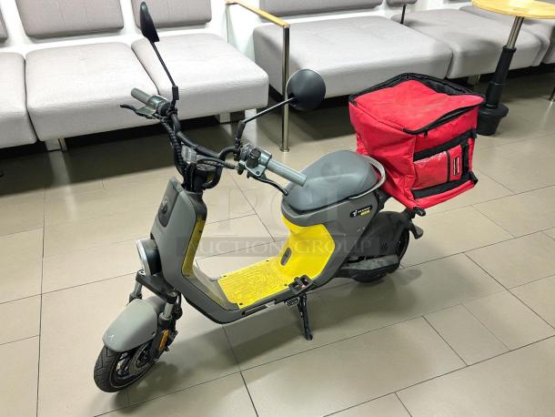 Segway eMoped C80 in like-new condition, gray and yellow with rear red cargo bag, ideal for urban commuting.